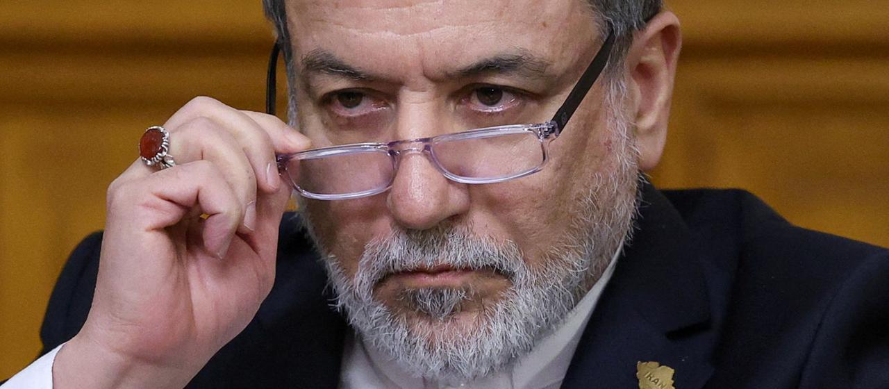 Abbas Araghchi pushes his glasses down his nose.