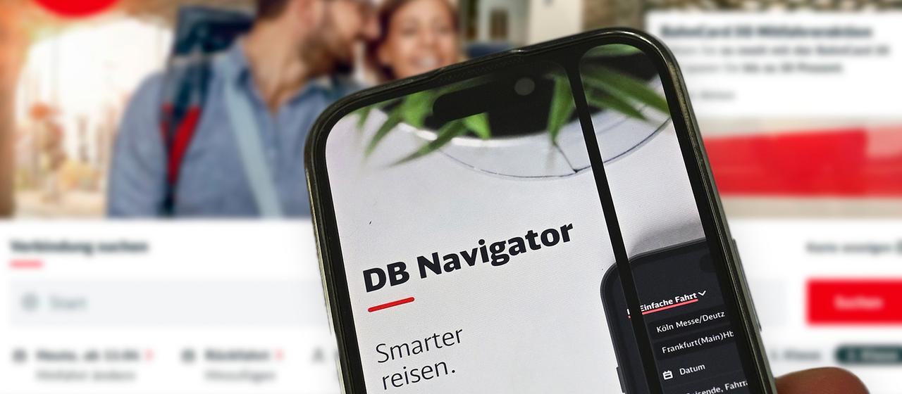 Ein  Smartphone mit der DB Navigatorapp vor einem Bildschirm.