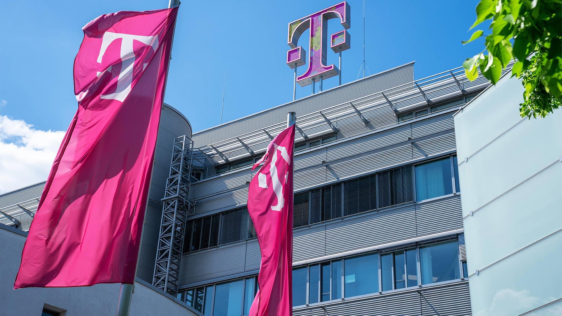 Fahnen mit dem Firmenlogo vor der Zentrale der Deutschen Telekom | picture alliance /