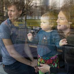 Eine Familie schaut durch ein Fenster nach draußen.