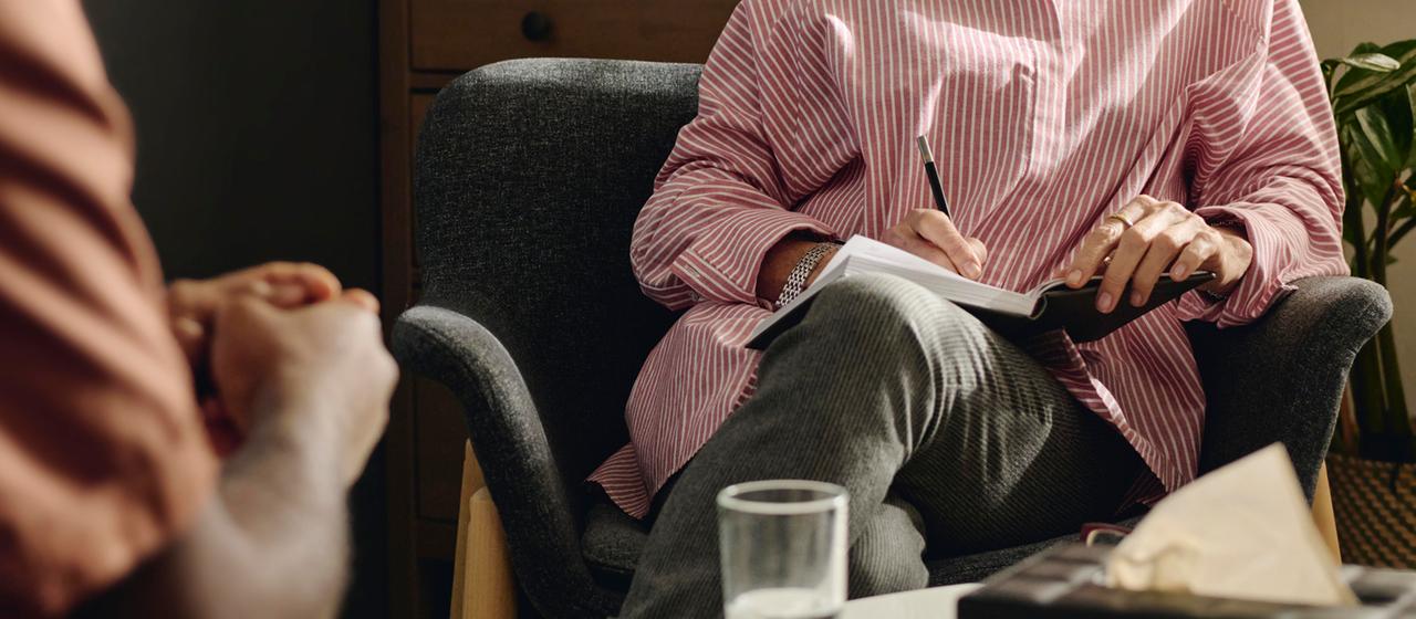 Cliente y terapeuta toman notas durante una sesión.