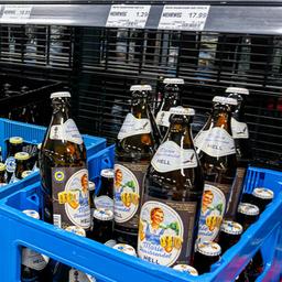 Bier und Biermischgetränke stehen in Kästen im Supermarktregal. 