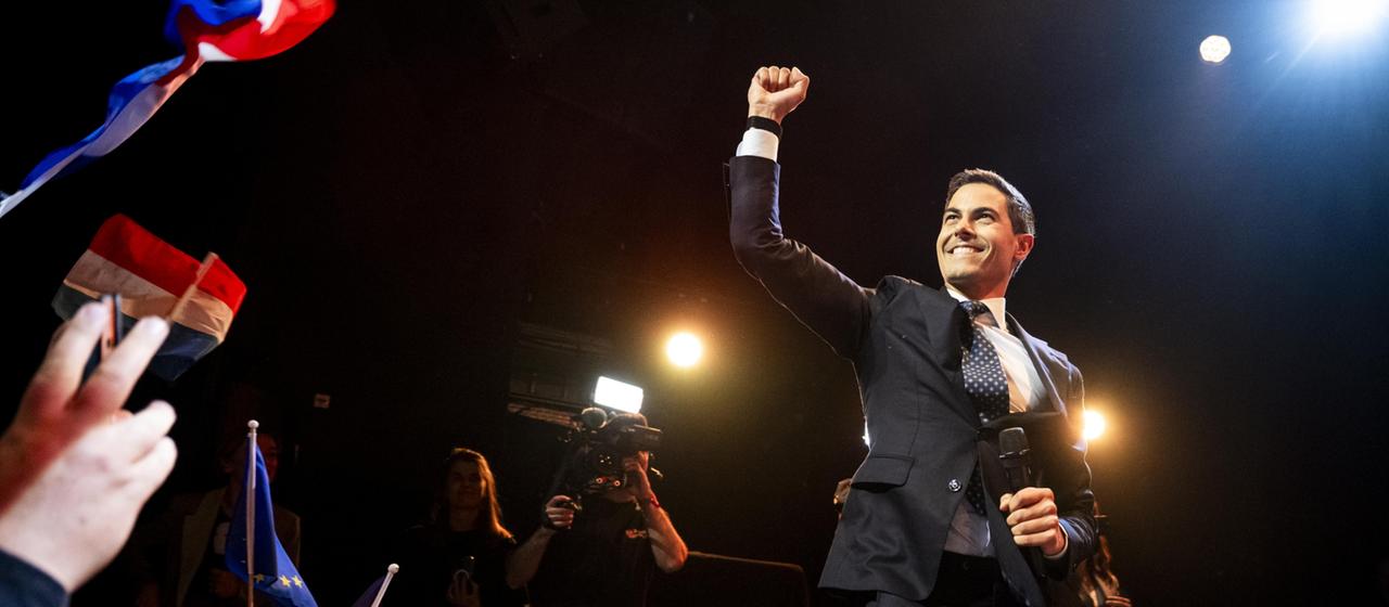 Rob Jetten hält bei einer Veranstaltung am Wahlabend lächelnd die Faust in die Höhe.