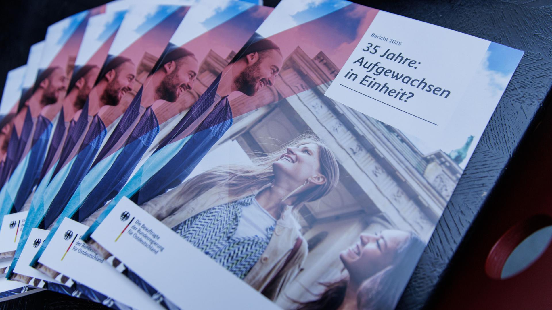 Gedruckte Exemplare vom Bericht zum Stand der Deutschen Einheit liegen auf dem Tisch bei einer Pressekonferenz anlässlich der Vorstellung des Berichtes zum Stand der Deutschen Einheit. | dpa