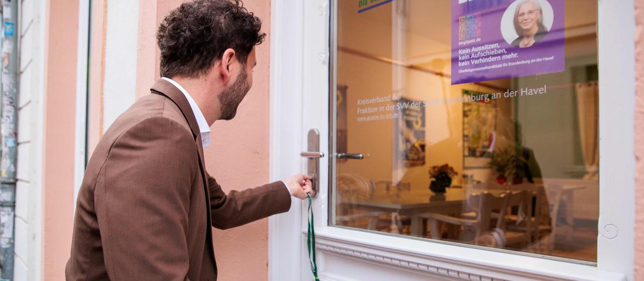Grünen-Chef Banaszak öffnet mit dem Hausschlüssel die Tür zu seinem neuen Regionalbüro