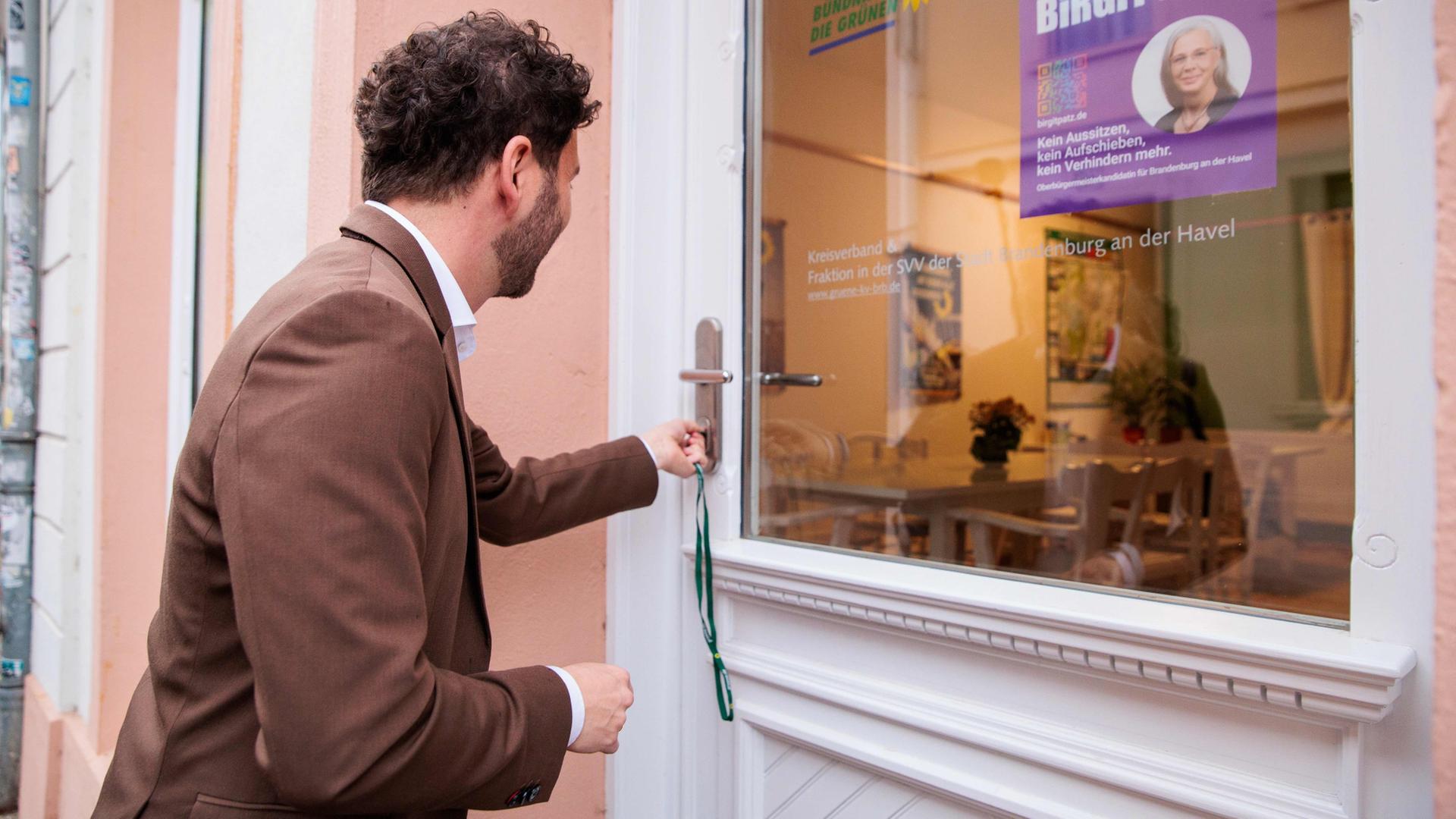 Grünen-Chef Banaszak öffnet mit dem Hausschlüssel die Tür zu seinem neuen Regionalbüro | dpa