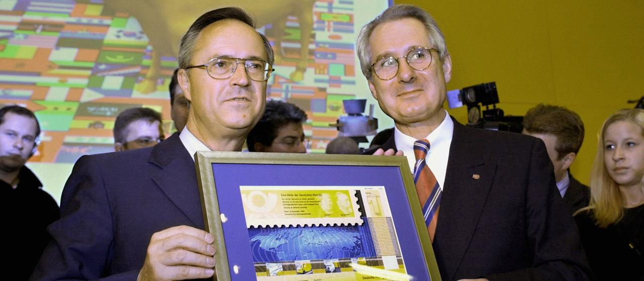 Hans Eichel und Klaus Zumwinkel halten am 20.11.2000 in Frankfurt/Main eine "Aktie Gelb" in den Händen. 