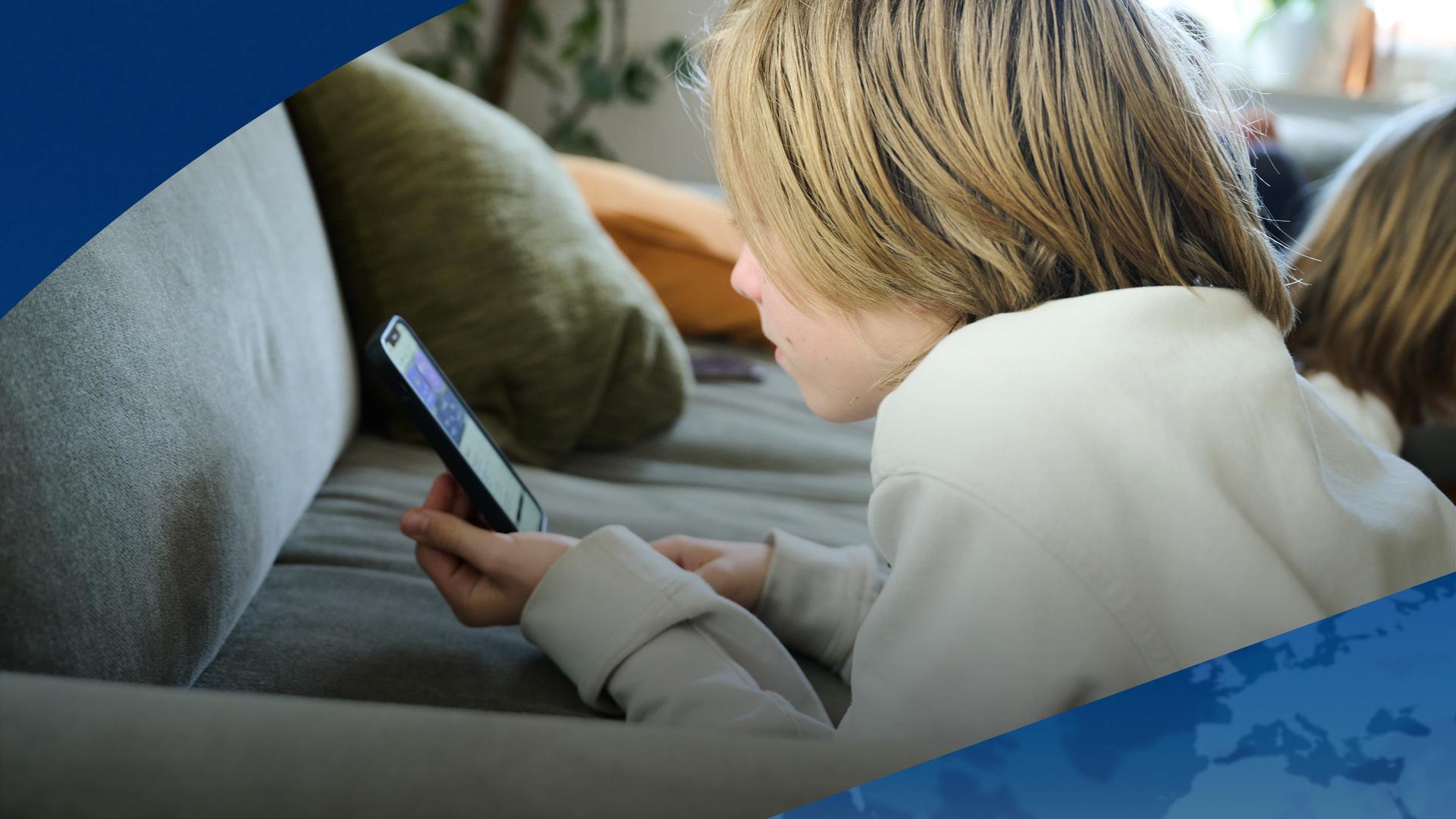 Ein Junge schaut auf sein Handy (Symbolfoto). | Symbolfoto: Annette Riedl/dpa