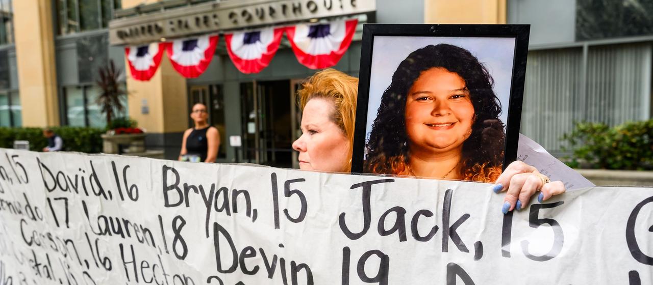 Im Prozess gegen Meta zeigen Angehörige vor dem Gerichtsgebäude in Oakland Fotos von toten Jugendlichen