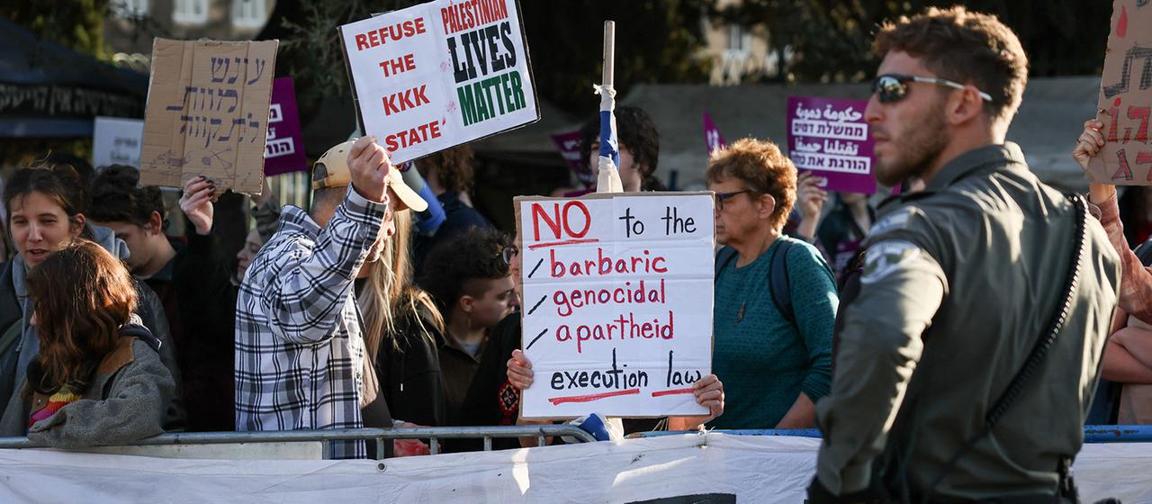 Demonstranten halten selbstgemalte Schilder.