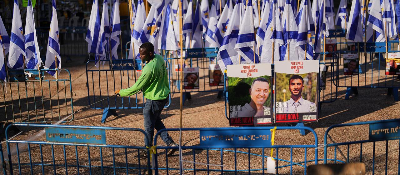 Ein Arbeiter reinigt den Boden auf dem Platz der Geiseln in Tel Aviv. | dpa Ein Arbeiter reinigt den Boden auf dem Platz der Geiseln in Tel Aviv.