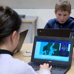 Kinder sitzen in einer schwedischen Schule vor Laptops