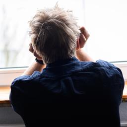 Ein Mann lehnt an einem Fenster