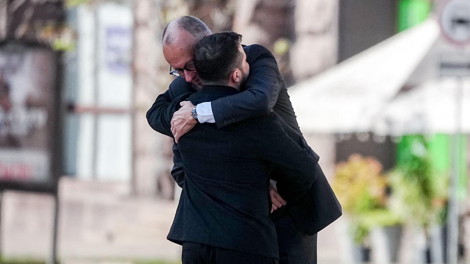 Friedrich Merz und Wolodymyr Selenskyj umarmen sich beim Gedenken am Maidan. | Kay Nietfeld/dpa