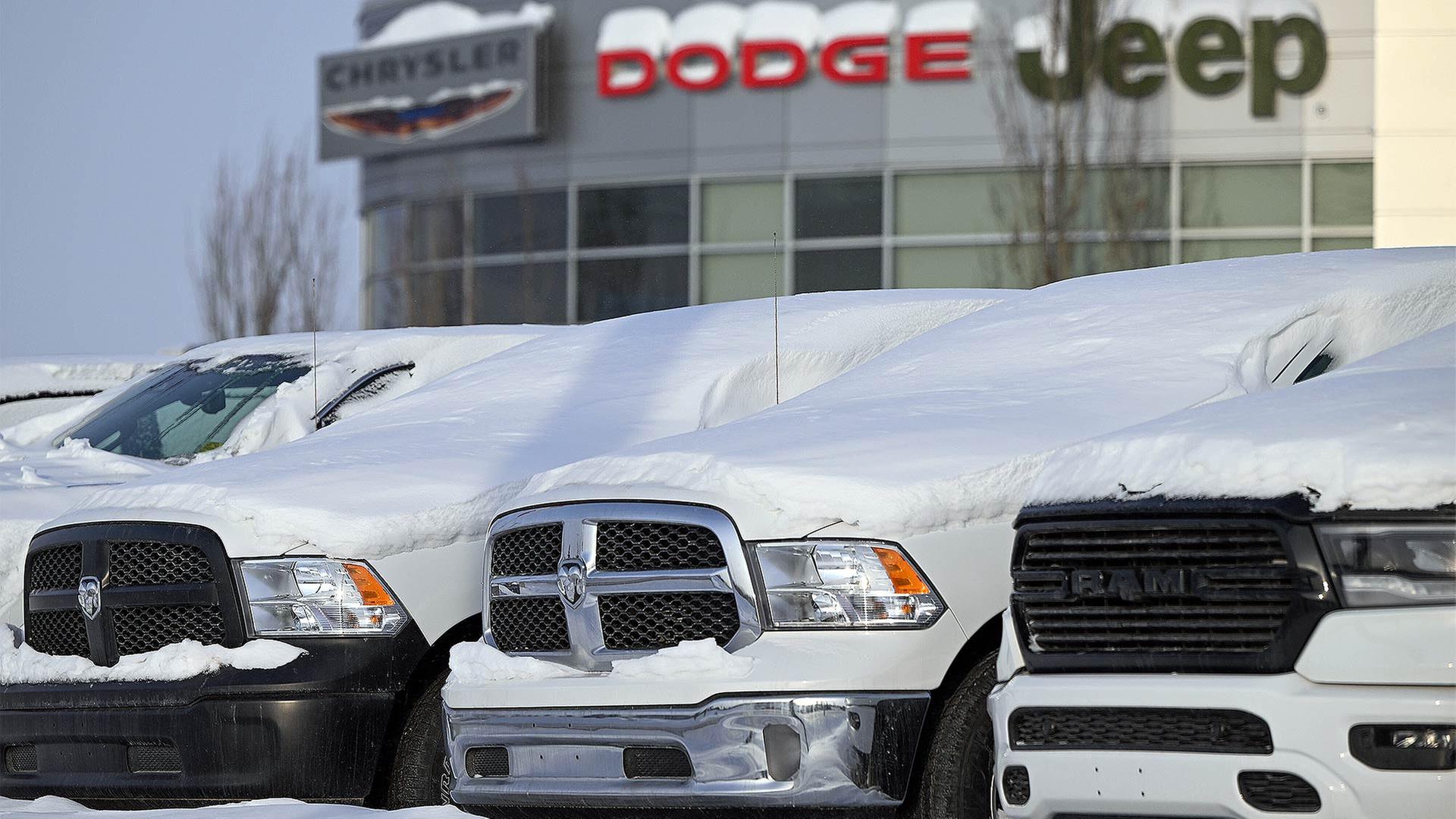 Schneebedeckte Fahrzeuge vor einem Autohändler der Marken Chrysler, Dodge, Jeep. | picture alliance / NurPhoto