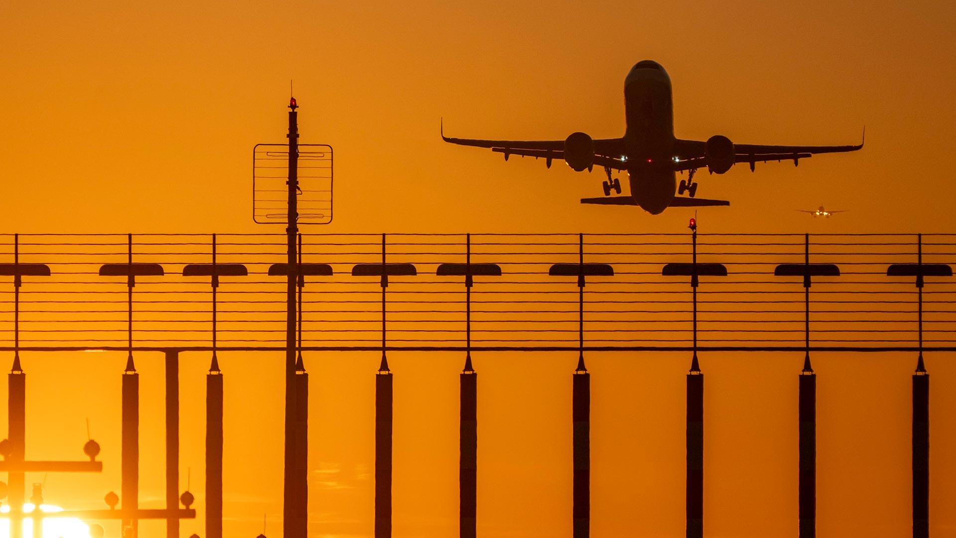 Flugzeug im Sonnenuntergang beim Start | picture alliance / Jochen Tack
