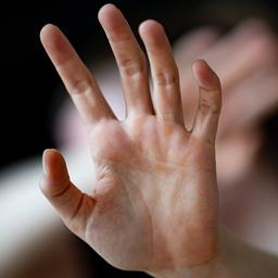 Eine Frau hält ihre Hände vor das Gesicht (unscharf)