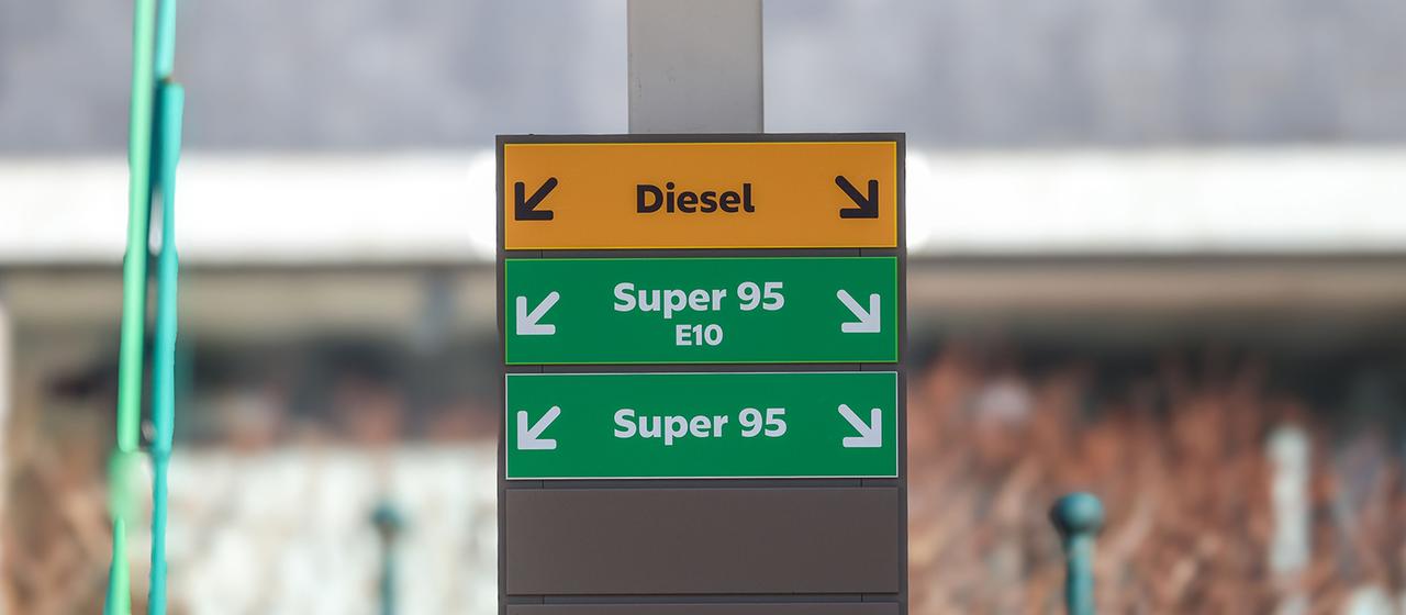 Hinweisschilder mit der Beschriftung «Diesel», «Super 95 E10» und «Super 95» weisen auf Zapfsäulen an einer Tankstelle hin. 
