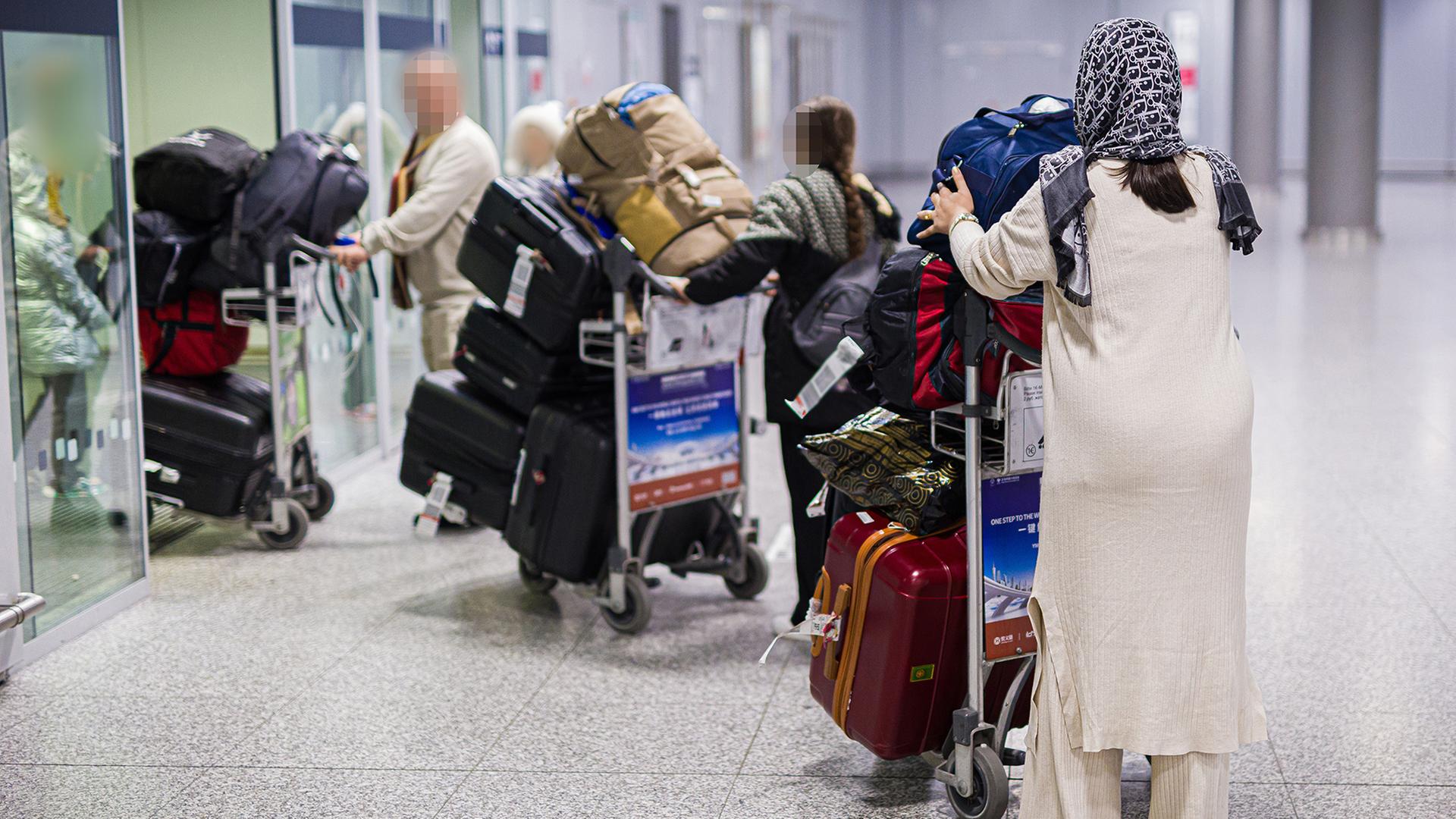 Menschen aus Afghanistan verlassen mit ihrem Gepäck das Flughafengebäude vom Flughafen Hannover-Langenhagen. | dpa