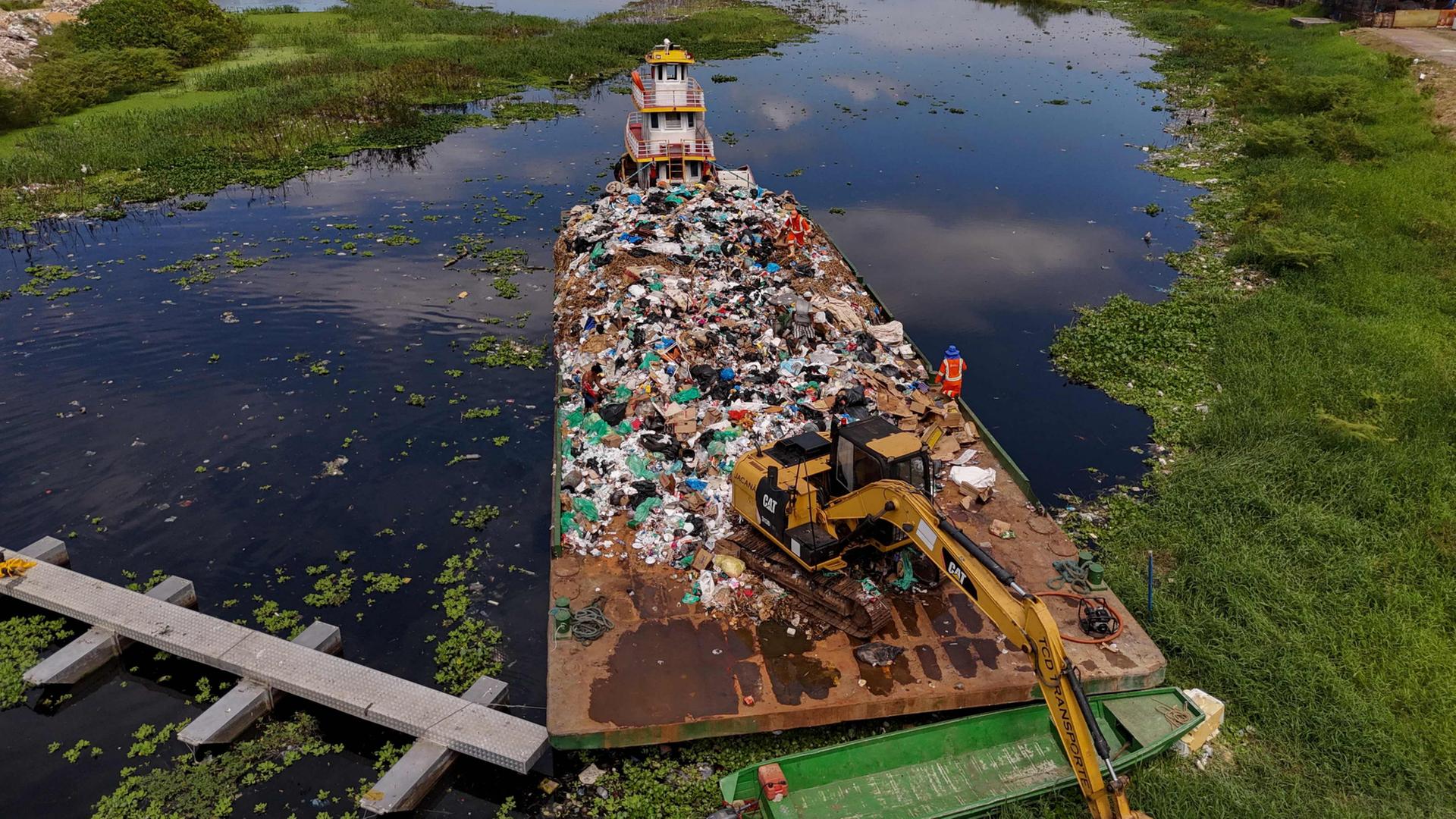 Ein Lastschiff transportiert eine groÃe Menge MÃ¼ll, der aus dem Rio Negro in Manaus im Norden Brasiliens geborgen wurde. | AFP