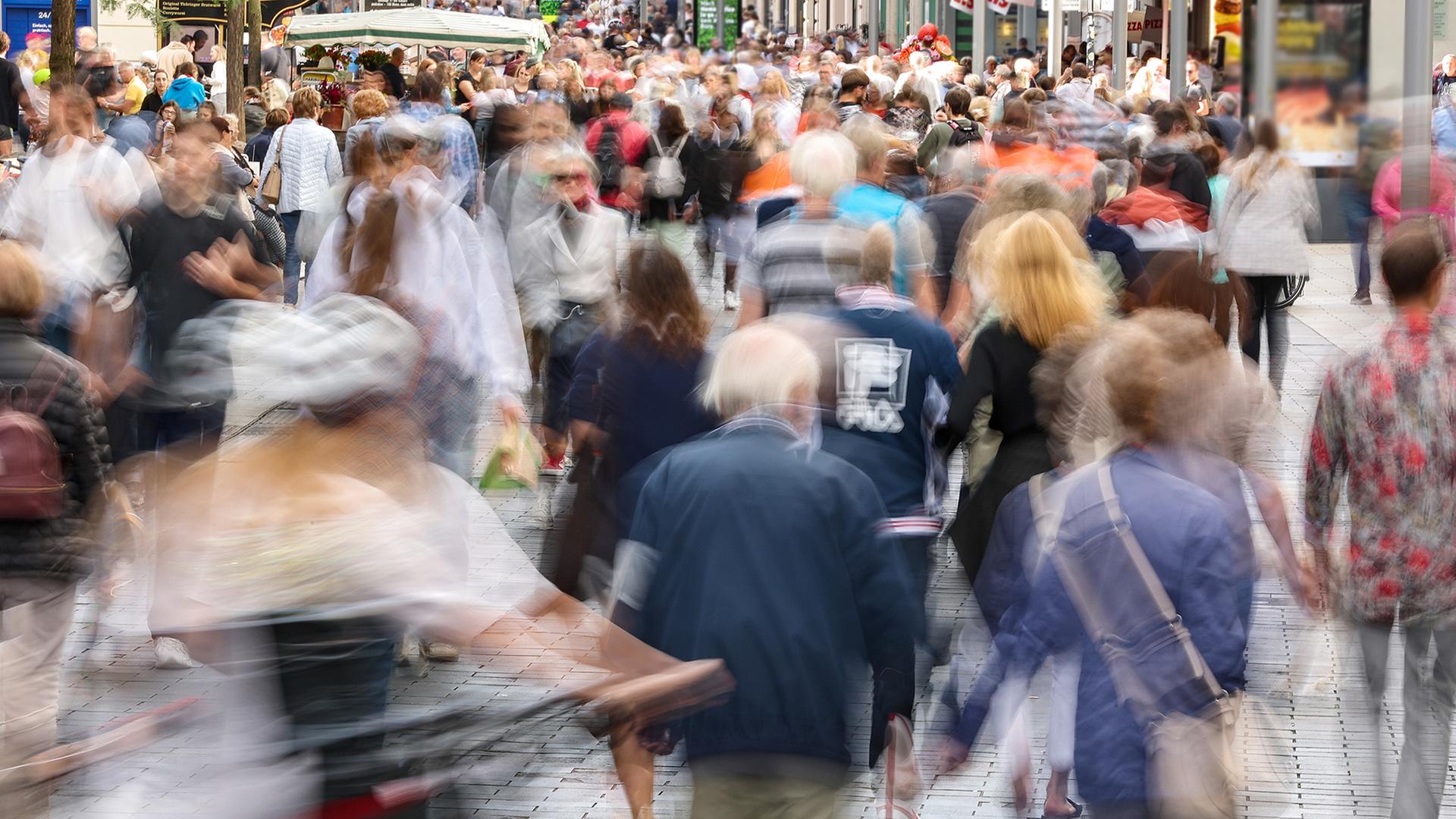 Zahlreiche Passanten gehen durch eine Straße in der Leipziger Innenstadt. | dpa