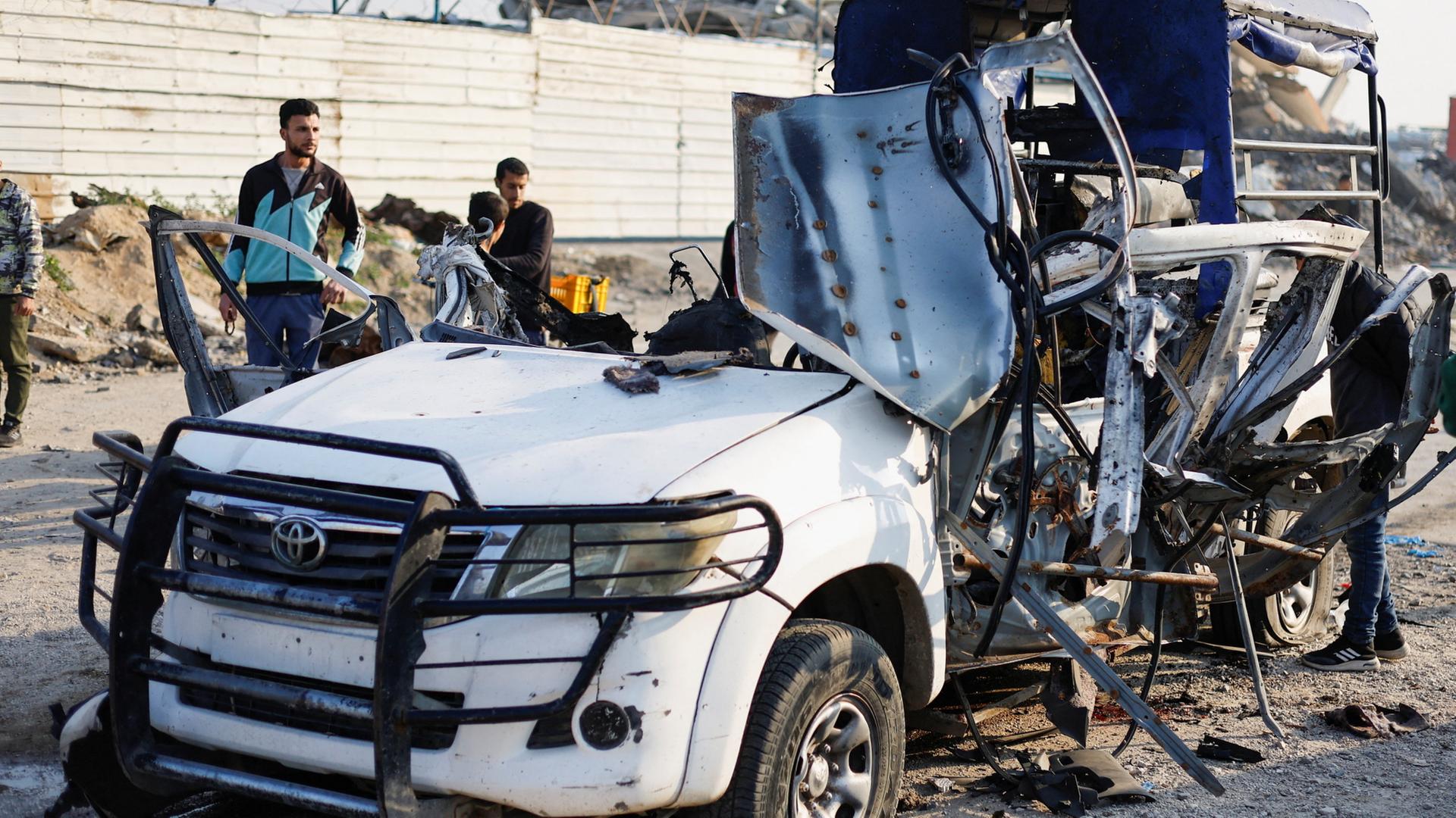 Menschen begutachten den Ort eines israelischen Luftangriffes auf ein Polizeiauto im Gazastreifen | REUTERS