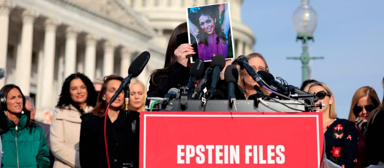 Vor dem Kapitol in Washington hält eine Frau, ein früheres Missbrauchsopfer Epsteins, ein Foto von sich vor ihr Gesicht. | Getty Images via AFP Vor dem Kapitol in Washington hält eine Frau, ein früheres Missbrauchsopfer Epsteins, ein Foto von sich vor ihr Gesicht.