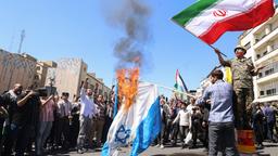 Menschen in Teheran verbrennen aus Protest gegen Israel Flaggen.