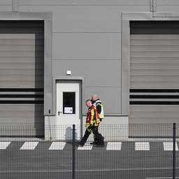 Mitarbeiter der Feuerwehr gehen auf dem Gelände der Tesla-Autofabrik in Grünheide, wo die Produktion wegen eines Stromausfalls stillsteht.