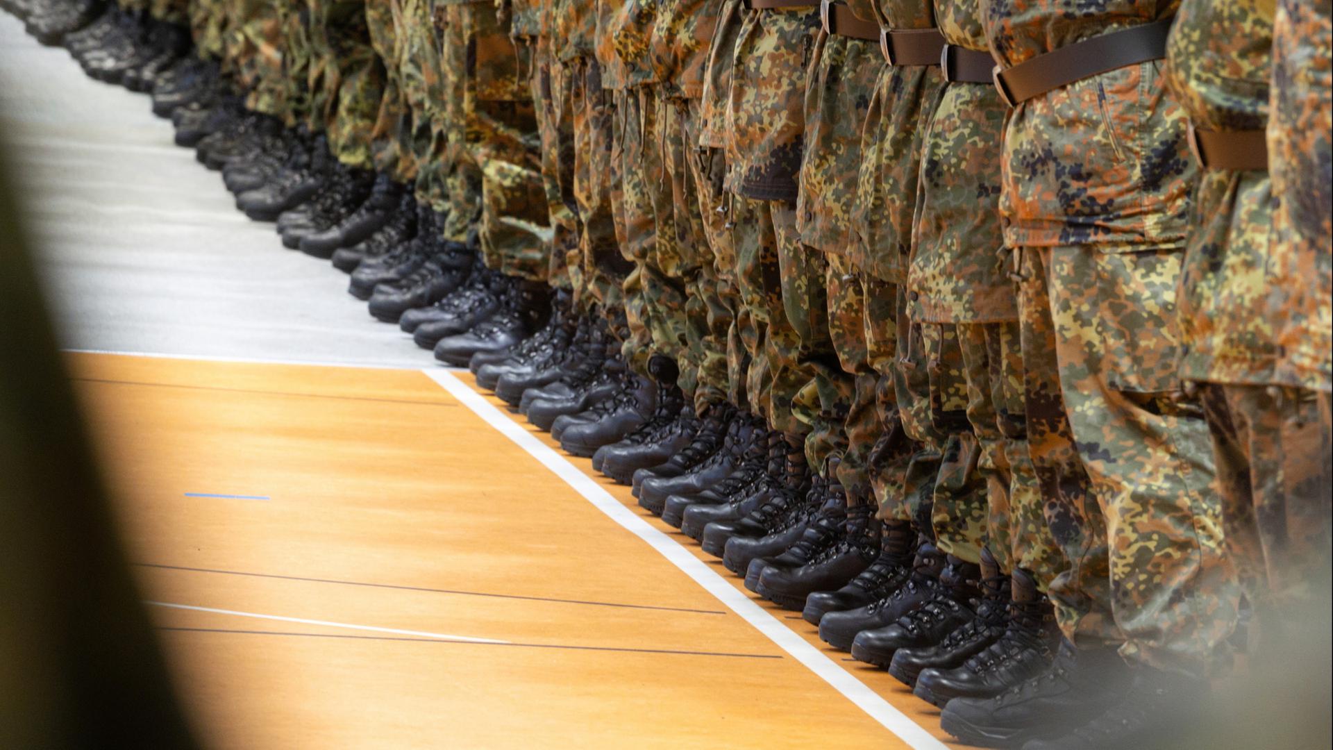 Die Schuhe von Soldatinnen und Soldaten bei einem öffentlichen Regimentsappell in einer Sporthalle | dpa