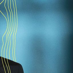 Bundeskanzler Olaf Scholz sitzt während eines Fototermins nach der Aufzeichnung seiner Neujahrsansprache im Kanzleramt vor der Kulisse des von Scheinwerfern angestrahlten Reichstages.