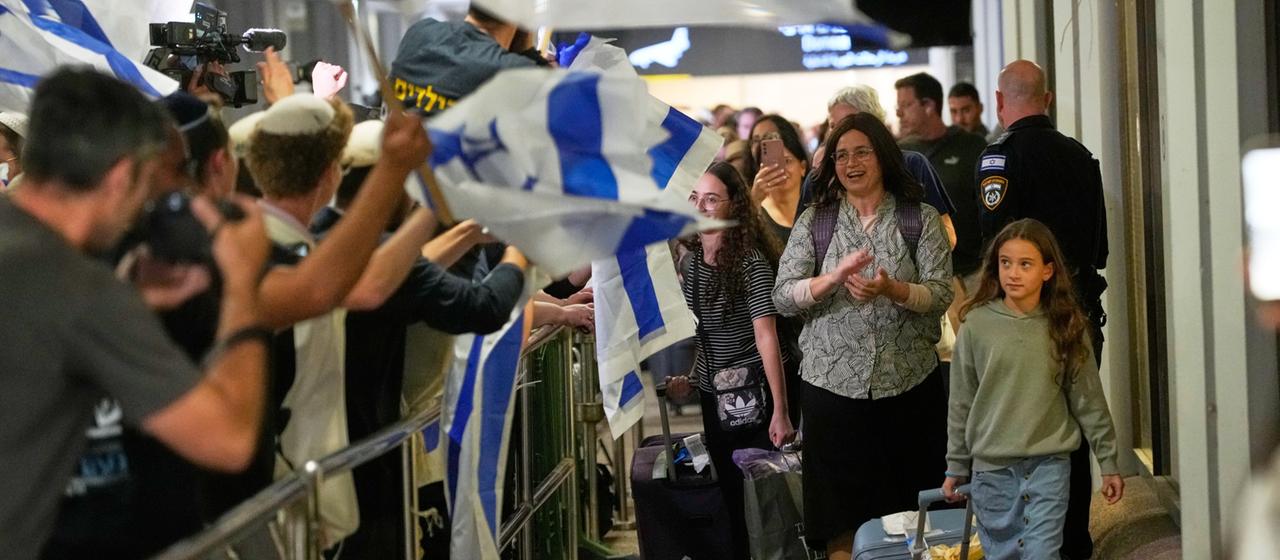Passagiere werden mit Israel-Flaggen am Flughafen in Tel Aviv empfangen
