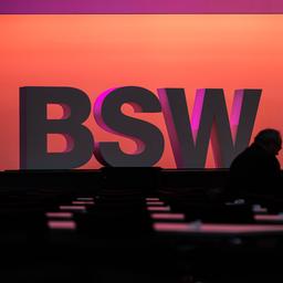 Menschen stehen vor einem BSW Schriftzug in Bonn.