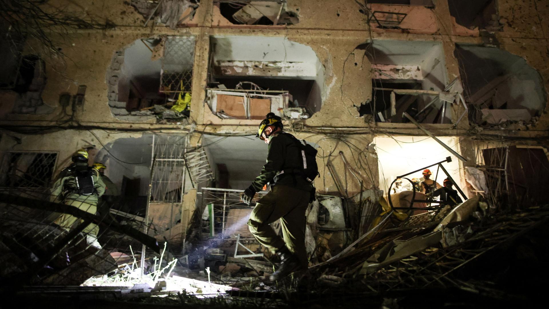 Israelische Einsatzkräfte begutachten Schäden nach dem Einschlag einer Rakete in Dimona.  | REUTERS