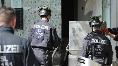 Polizisten sichern im Rahmen einer Razzia Beweismittel