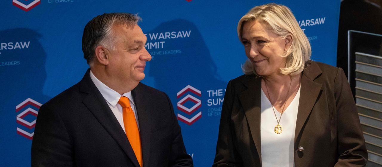 Ungarns Regierungschef Orban und Frankreichs Le Pen lächeln beim Warschauer Treffen der Rechtskonservativen an.