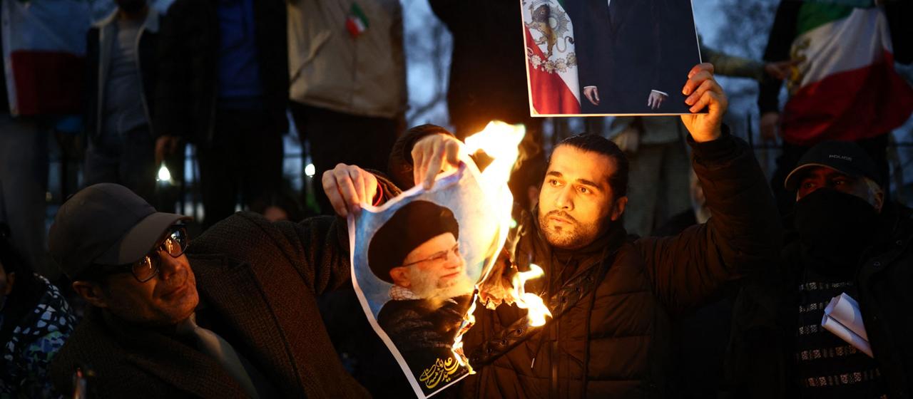 Ein Mann verbrennt ein Bild von Ajatollah Ali Chamenei.