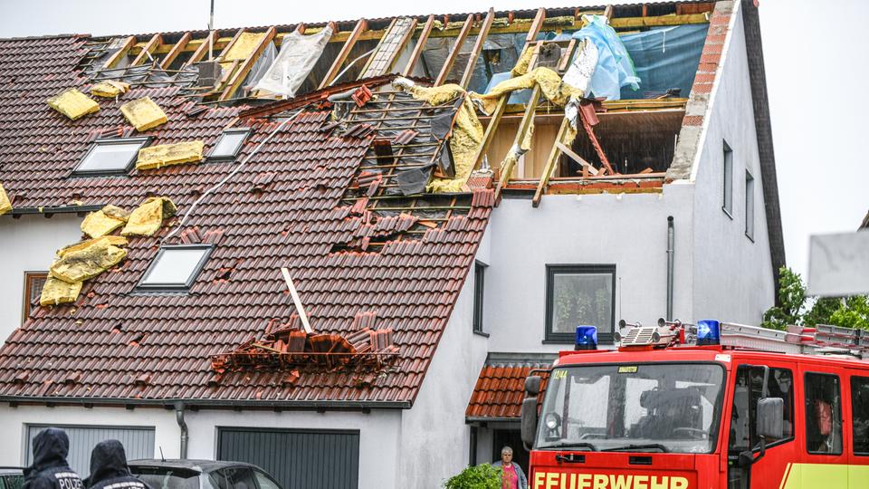 Ein Feuerwehrfahrzeug steht neben einem beschädigten Haus in Ulm.