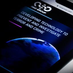 Eine Illustration zeigt ein Smartphone mit der Webseite von NSO.