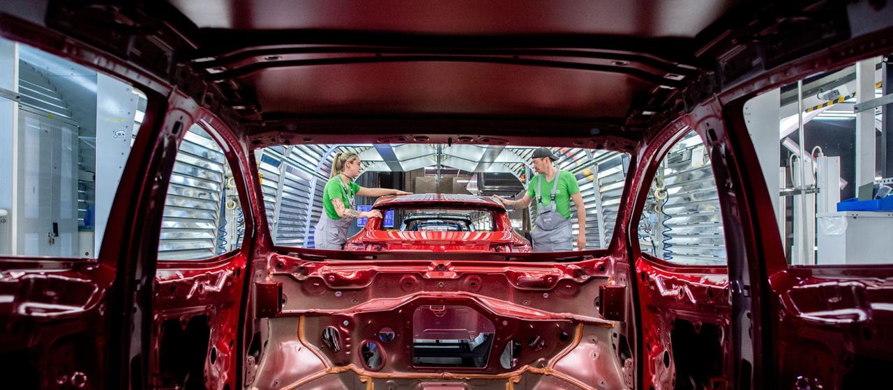 Mitarbeiter überprüfen im Lichttunnel der Lackiererei im Werk von Volkswagen den Lack einer Karosserie. (Archivbild: 24.02.2026)