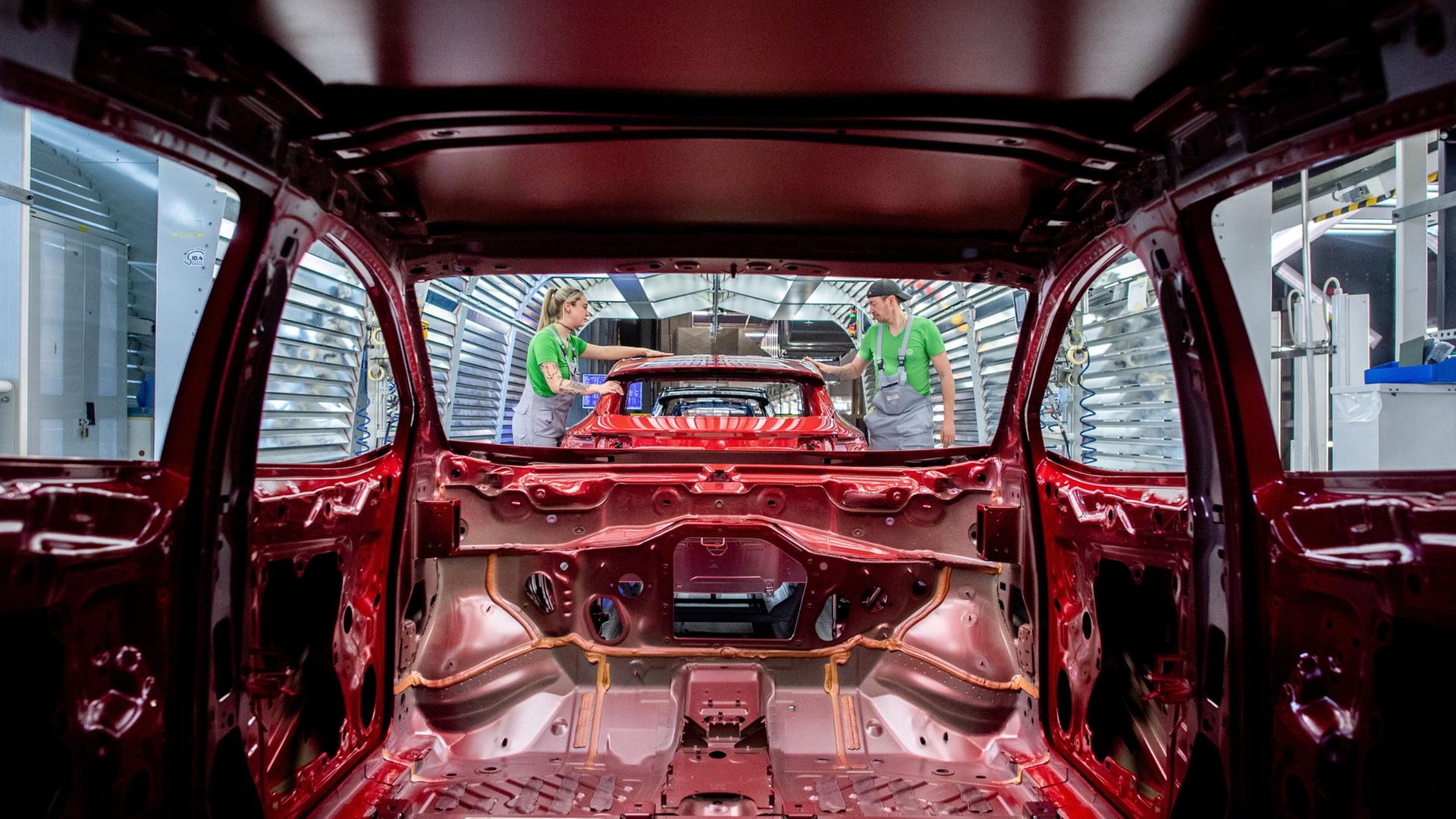 Mitarbeiter �berpr�fen im Lichttunnel der Lackiererei im Werk von Volkswagen den Lack einer Karosserie. (Archivbild: 24.02.2026) | Hauke-Christian Dittrich/dpa 