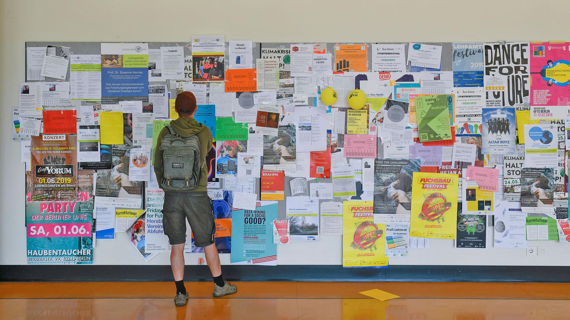Ein Student liest Anzeigen auf dem Schwarze Brett an der Freien Universität Berlin. (Quelle: Picture Alliance/Schoening) | Picture Alliance/Schoening