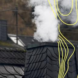 Am Nachmittag dampft ein Schornstein auf einem Haus in Siegen-Oberschelden.