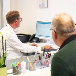 Ein Arzt spricht mit einem Patienten.