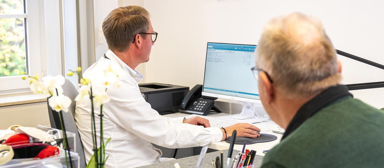 Ein Arzt spricht mit einem Patienten.