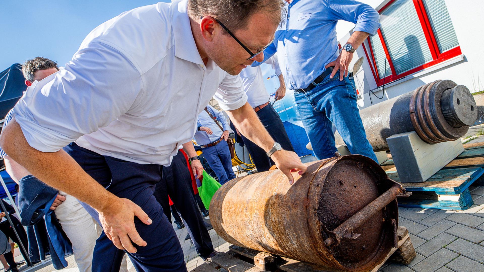 Carsten Schneider beugt sich �ber eine verrostete Weltkriegsbombe | Jens B�ttner/dpa