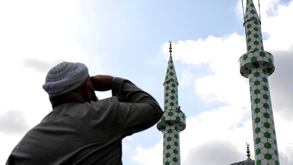 Ein Mann beobachtet ein Minarett an der Centrum-Moschee in Hamburg. (September 2009)