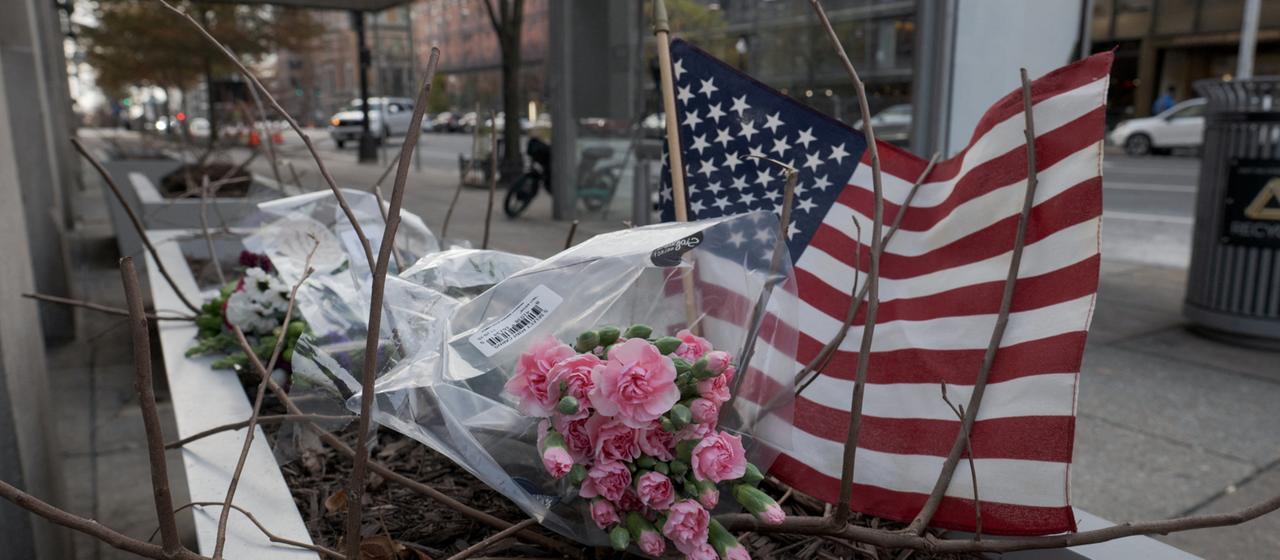 Blumen und eine US-Flagge nahe der Metrostation Farragut West in Washington