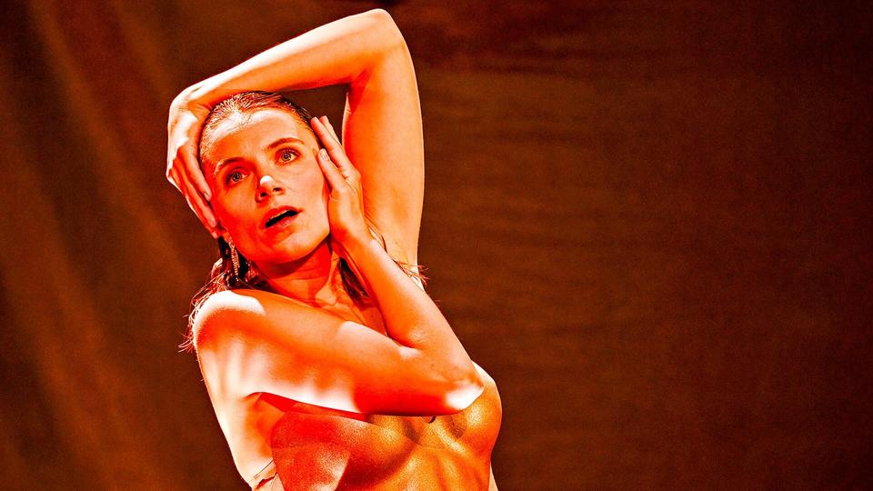 Henriette Hölzel spielt in dem Stück solo – ein Monolog um die "Nein heißt Nein"-Debatte und sexuelle Selbstbestimmung. | Sebastian Hoppe Henriette Hölzel im Theaterstück "Prima Facie" in Dresden: Junge Frau auf einer Bühne mit nacktem Oberkörper - die Arme um Brust und Kopf geschlungen