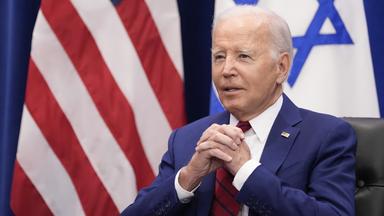 Joe Biden vor den Flaggen der USA und Israel